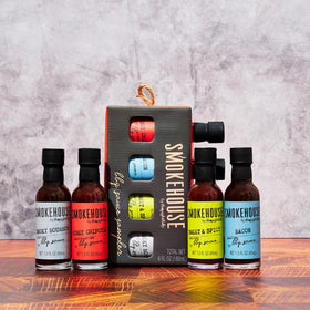 Thoughtfully Smokehouse four-bottle sampler on a grill-ready setup.
