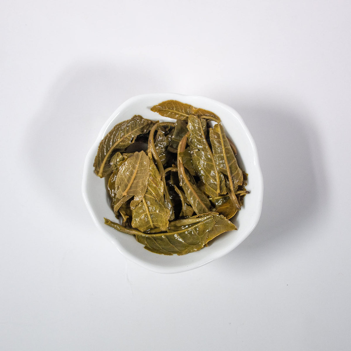 Sliced jasmine buds with green tea leaves emphasize natural ingredients and absence of artificial flavors.