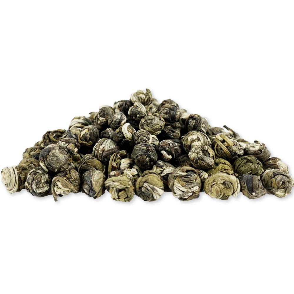 Close-up of pearl grains in a jar illustrates careful production for high-quality jasmine tea.