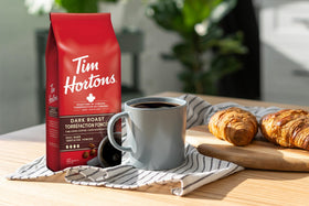 Tim Hortons dark roast cup with sip, pairs well with cream for smooth flavor.