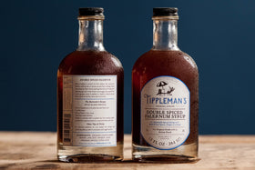 Close-up of whole spices and lime zest in Tippleman's falernum
