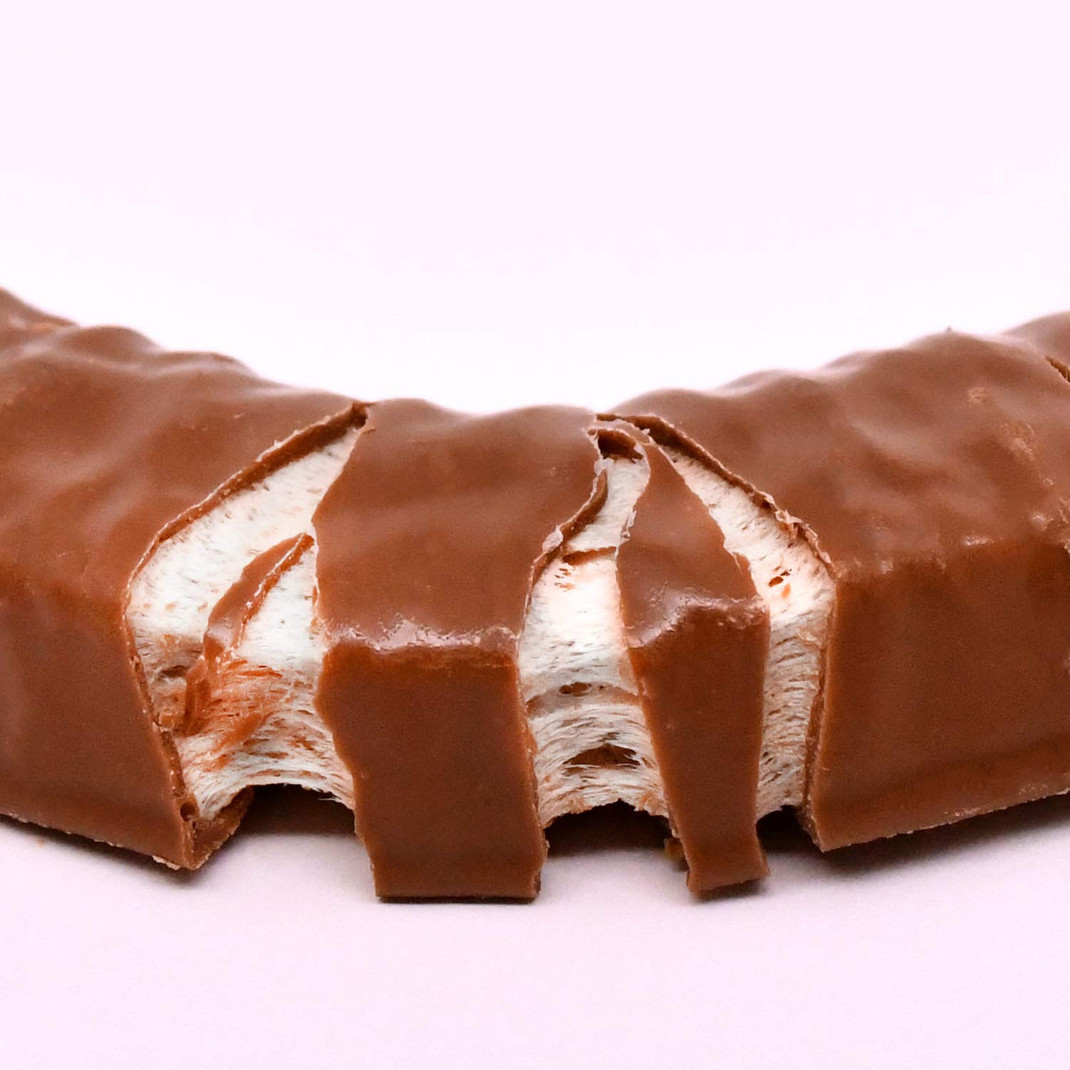 Close-up of vanilla Charleston Chew bar with rich chocolate coating.