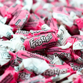 Tootsie Roll Frooties pink wrappers closeup highlighting chewy texture and fruity flavor.