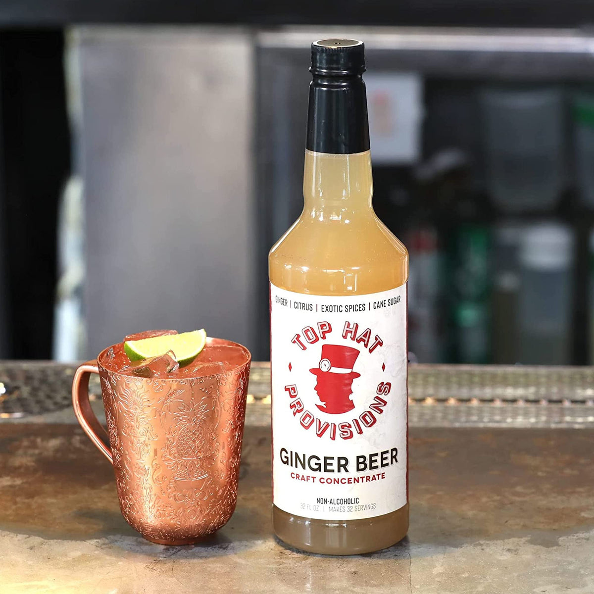 Ginger beer syrup bottle with glasses and lime for a refreshing Moscow Mule.