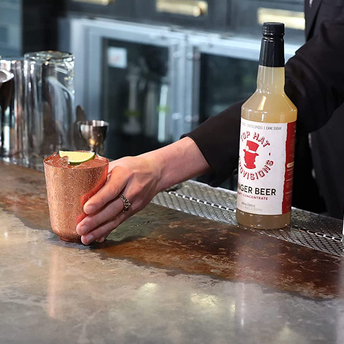 Lifestyle table setup with Top Hat Provisions syrup for simple home bartending.
