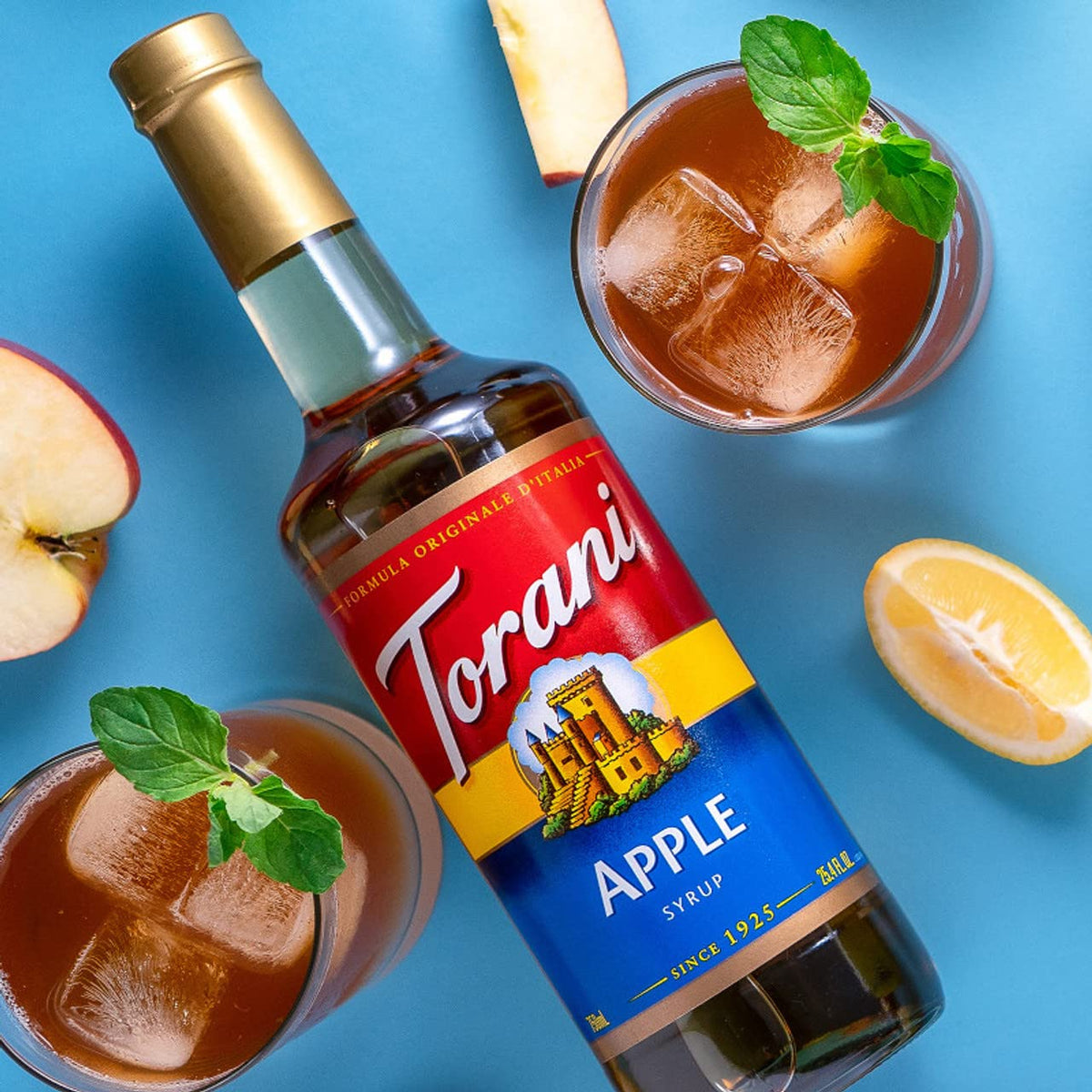 Torani Apple Syrup bottle next to cocktail ingredients for mixing