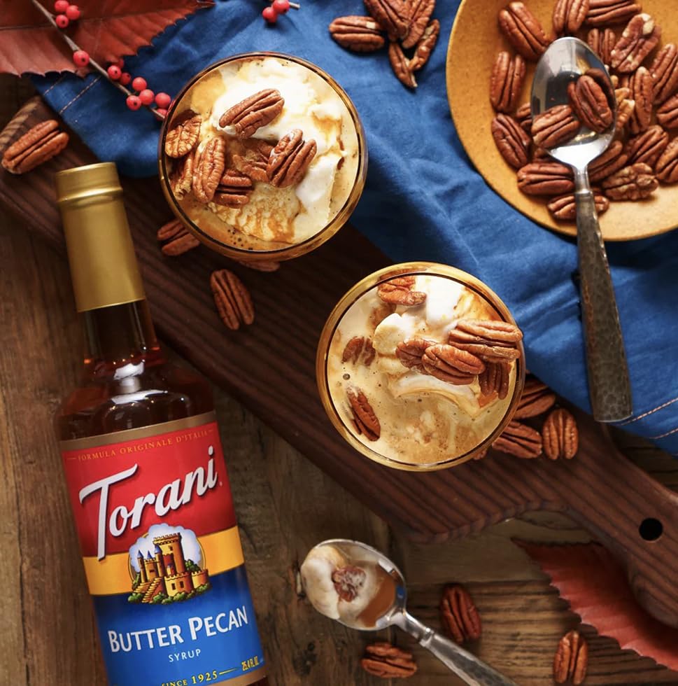 Pouring Torani Butter Pecan Syrup into a latte for depth.