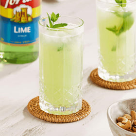 Torani Lime Syrup being poured into a glass for bright beverages.
