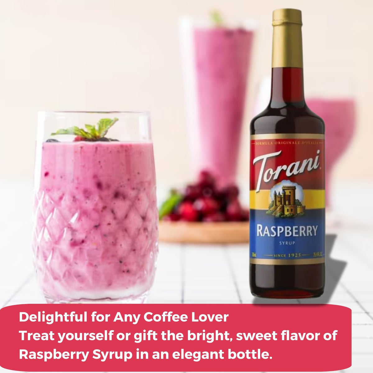 Torani raspberry syrup bottle beside the dispenser packaging.