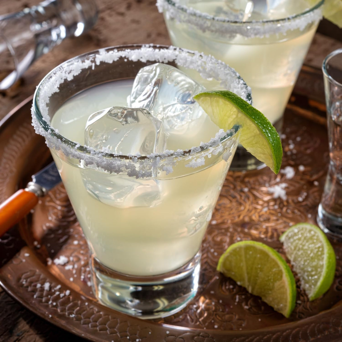 Pour-ready bottle alongside lime wedge for quick cocktails.