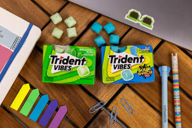 Trident Vibes Blue Raspberry gum bursting from sour to sweet flavor.