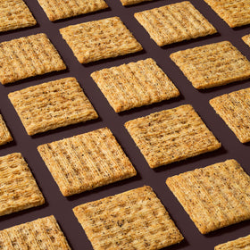 Triscuit Cracked Pepper & Olive Oil crackers served with cheese on a board.