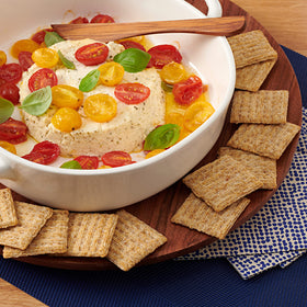 Triscuit Original with cheese and fruit on a board.