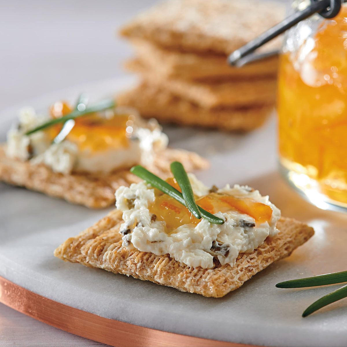 Triscuit Original crackers on a plate with toppings.