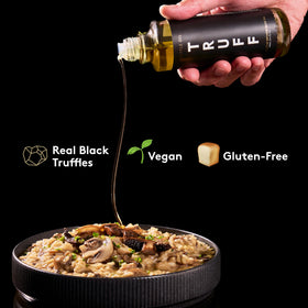 Close-up of TRUFF Black Truffle Oil being poured for a gourmet finish.