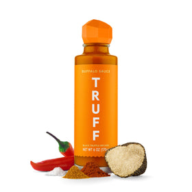 TRUFF Buffalo Sauce bottle pour showcasing luxury flavor with black truffle oil for gourmet drizzling.