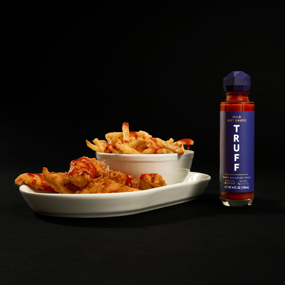 TRUFF Mild Hot Sauce 2-Pack dipping-plate scene suggests versatile dipping.