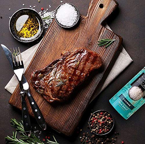 Sprinkling Tuscanini salt over grilled steak to enhance savory crust.