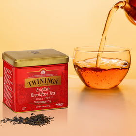 Twinings English Breakfast brew in cup with steam, bold flavor in minutes.