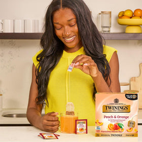 Twinings Peach & Orange herbal tea bag in cup ready to steep for a refreshing sip.