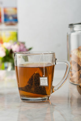 Hot tea being poured over bergamot-infused sachet, Two Leaves and a Bud.