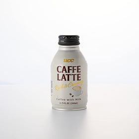 UCC Caffe Latte being poured into a mug, showcasing creamy texture.