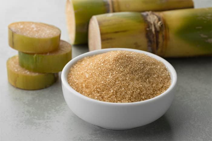 Unpretentious cane sugar in a measuring cup ready for precise recipes.