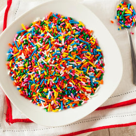 Unpretentious Rainbow Sprinkles topping on cupcakes for a festive look