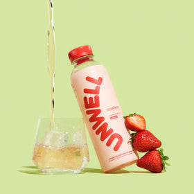Unwell Hydration strawberry pour into a glass for quick hydration after training.
