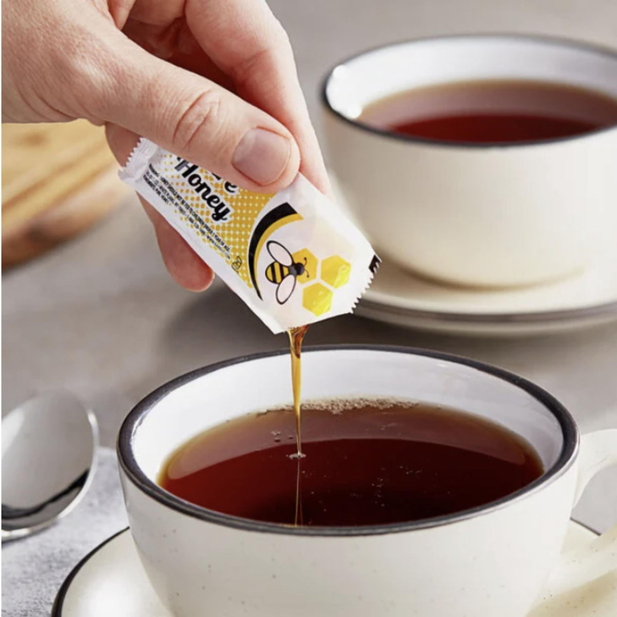 Vallary honey packets in open packaging on kitchen counter for easy sweetening.