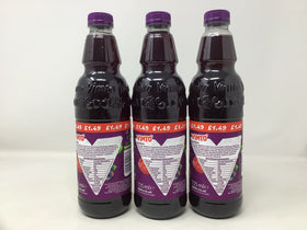 Pouring Vimto Squash into a glass, vibrant color ready to dilute for a refreshing drink.