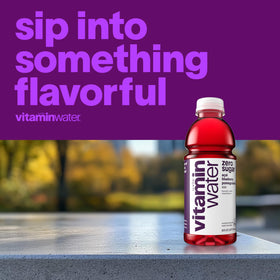 Pouring Vitaminwater XXX acai-blueberry-pomegranate into a glass for a refreshing workout break