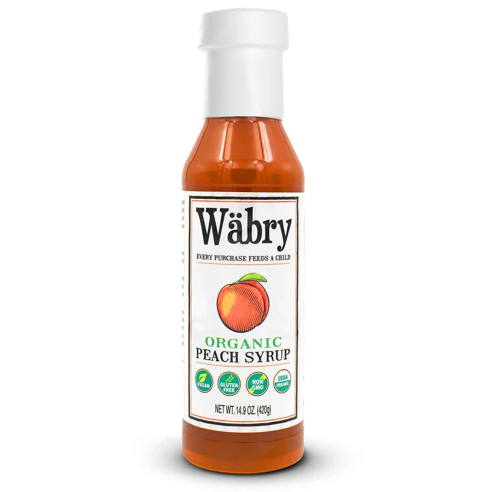 Wäbry Organic Peach Syrup bottle on kitchen counter, ideal for pancakes and beverages