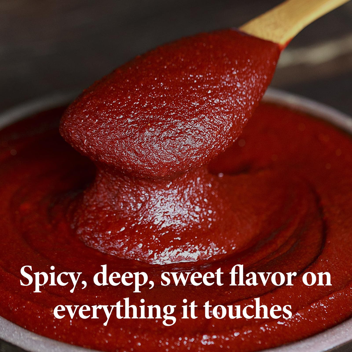 Wang Gochujang spoon dipping from jar, ready to spice sauces.