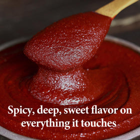 Wang Gochujang spoon dipping from jar, ready to spice sauces.
