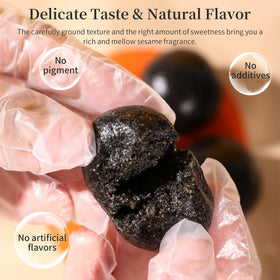 Close-up of glossy sesame seeds and chewy texture with honey aroma on a black sesame ball.