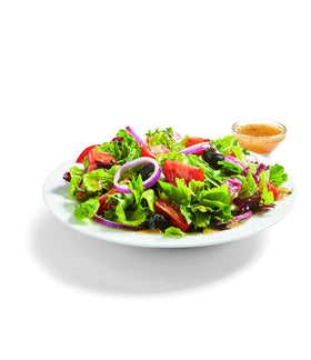 Pouring dressing from Watkins Organic Italian Dressing Mix into a bowl.