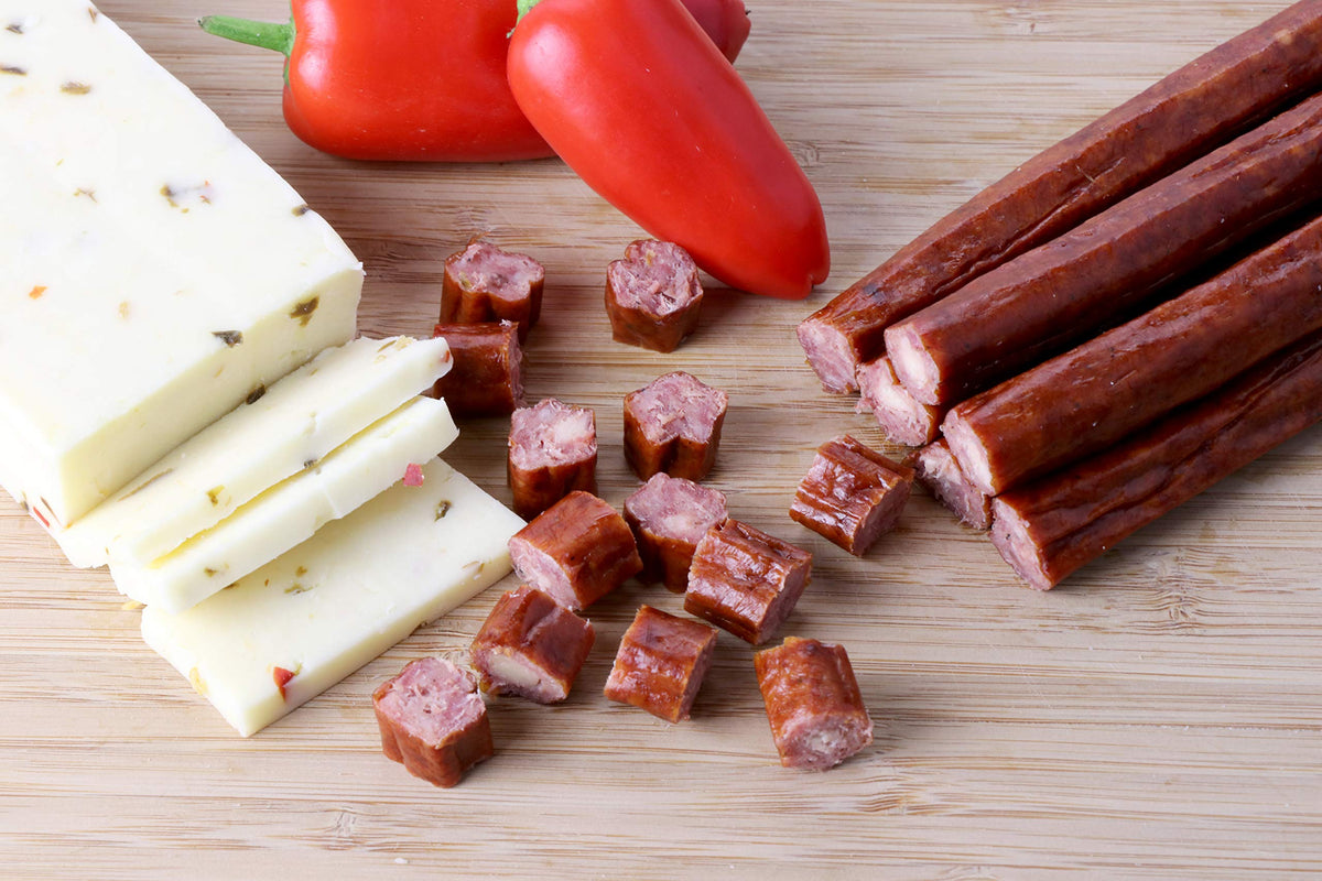 Plated Wenzel's Farm beef pepperjack sticks with nuts, ideal protein on-the-go.