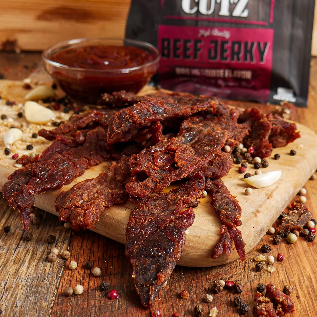 Wicked Cutz jerky slices arranged on a wooden board for snacking