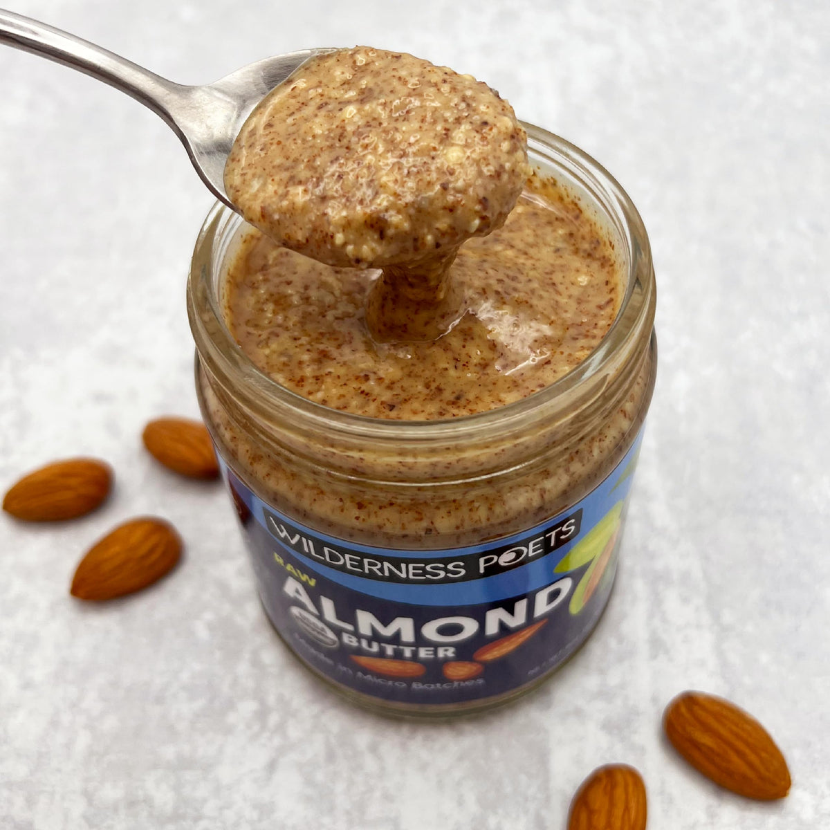 Wilderness Poets almond butter with spoon invites quick, satisfying snacking.