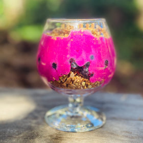 Wilderness Poets Pink Pitaya Powder in a glass to tint juice naturally