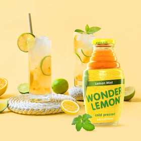 A pour-ready glass of Wonder Lemon Lemon Mint Juice over ice with mint garnish.