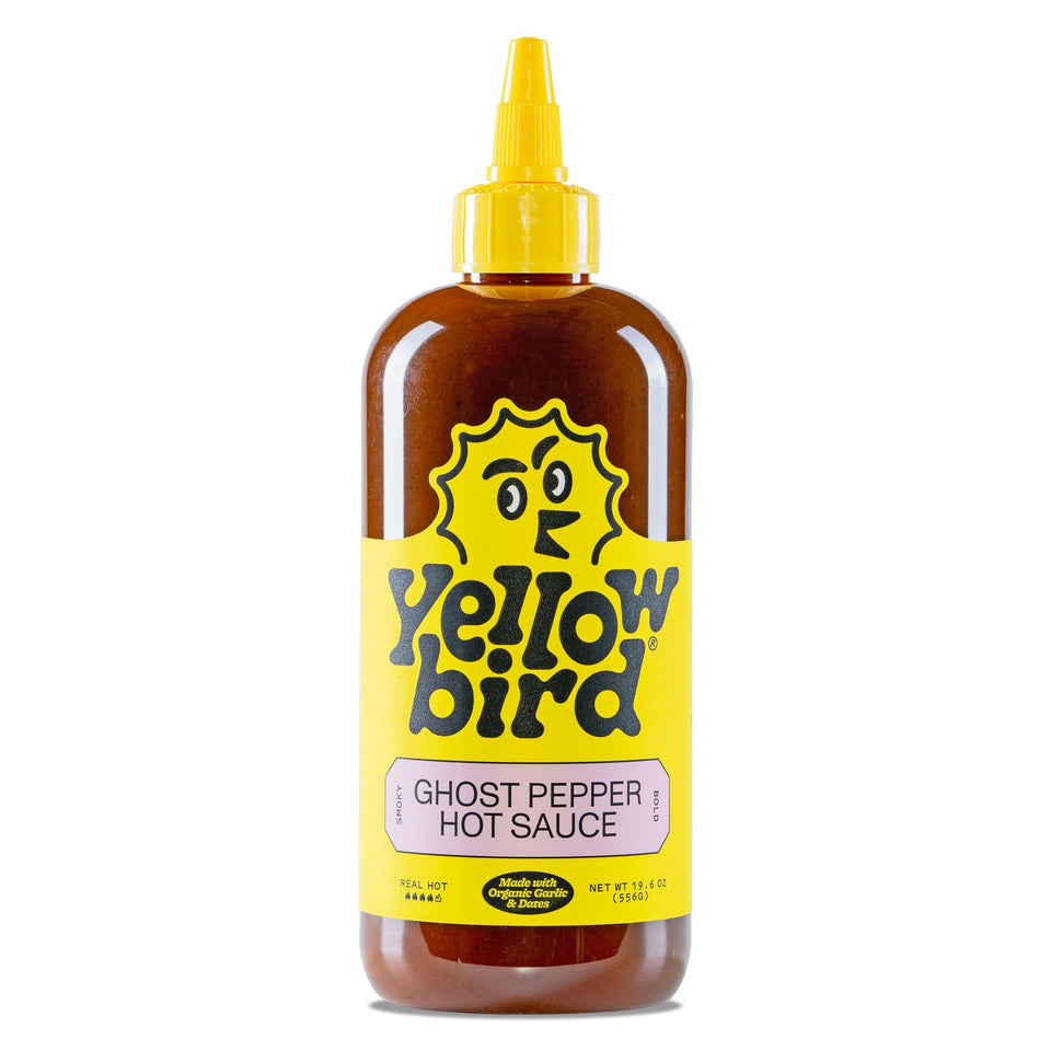 Yellowbird Ghost Pepper hot sauce bottle on table ready to spice up meals.