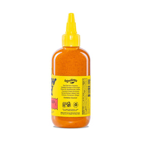 Texas-made Yellowbird sauce bottle on wooden board