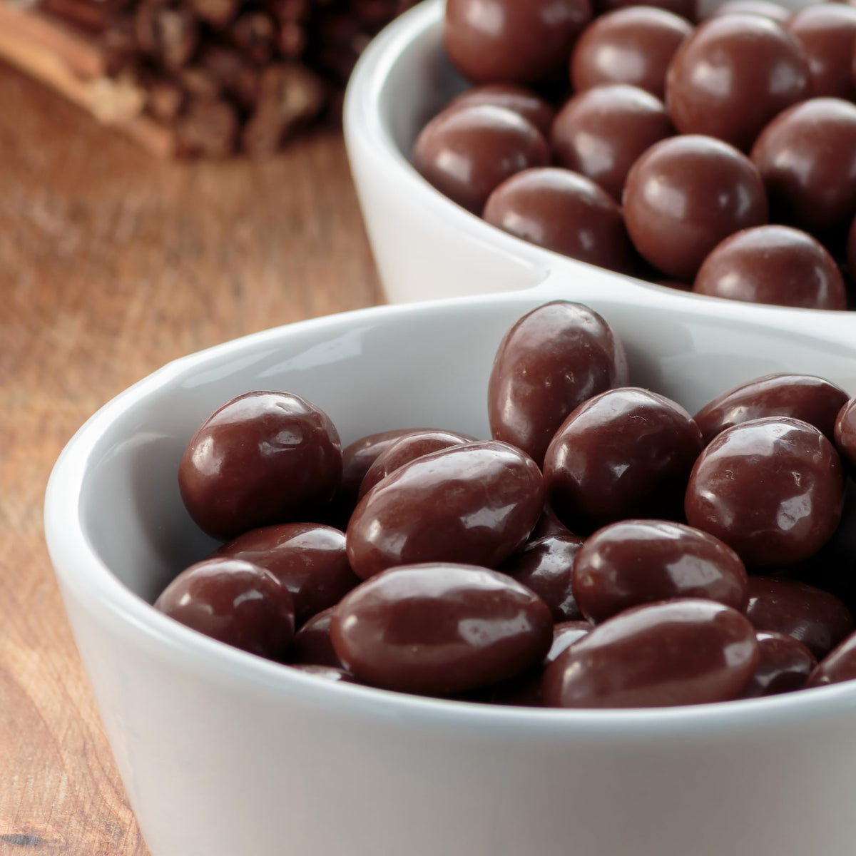 Yupik dark chocolate coconut almonds coating close-up, smooth shell over whole nuts.