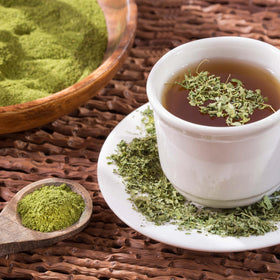 Yupik Moringa powder with scoop in a glass for a nutritious smoothie