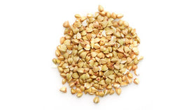 Yupik white buckwheat groats held in hand for versatile cooking