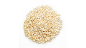 Yupik Quinoa Flakes being scooped into a bowl for breakfast.