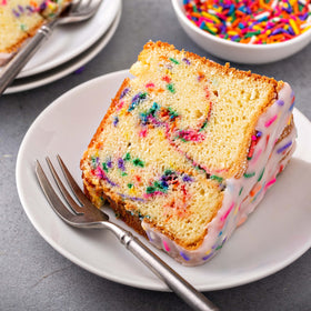 Yupik Rainbow Sprinkles being sprinkled over a cake for festive flair.