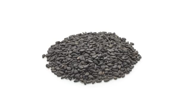 Yupik raw black sesame seeds poured over rice for nutty flavor